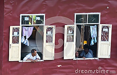 Maing Thauk, Myanmar - April 2019: old Burmese man looking out of the floating house window Editorial Stock Photo