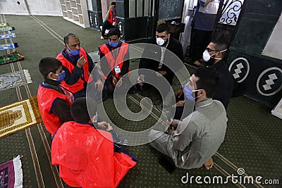 Maintaining the social distancing, gather to perform Eid al-Fitr prayer in a sports court within precautions against the novel cor Editorial Stock Photo