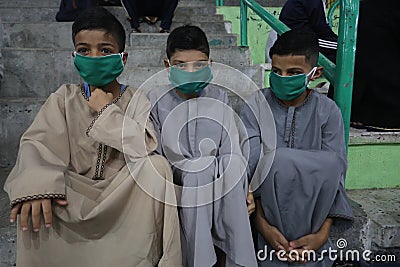 Maintaining the social distancing, gather to perform Eid al-Fitr prayer in a sports court within precautions against the novel cor Editorial Stock Photo