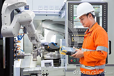 Maintenance engineer programing automated robotic with CNC Stock Photo