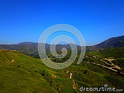 a majestic aerial shot of the lush green hillsides and mountains with a long winding road Stock Photo