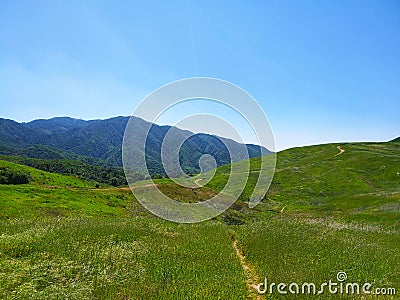 a majestic aerial shot of the lush green hillsides and mountains with a long winding road Stock Photo