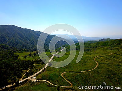 a majestic aerial shot of the lush green hillsides and mountains with a long winding road Stock Photo
