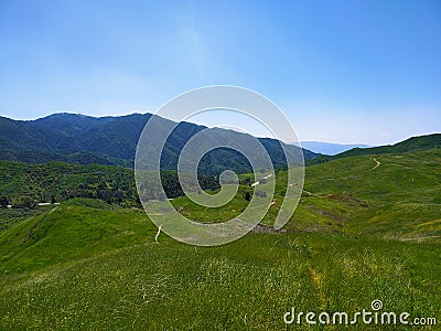 a majestic aerial shot of the lush green hillsides and mountains with a long winding road Stock Photo