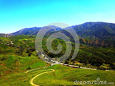 a majestic shot of the lush green hillsides and mountains with a long winding road Stock Photo