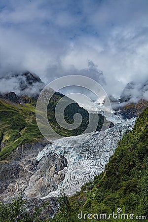 The majestic snow-capped mountains are covered by thick clouds Stock Photo