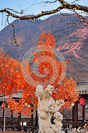 Majestic statue standing against a stunning backdrop of vibrant foliage and mountain. Editorial Stock Photo