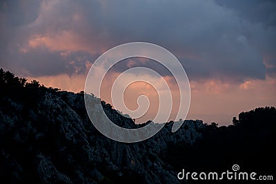 Majestic view on sky and clouds at sunrise. Dark silhouettes of mountains at dawn. Stock Photo