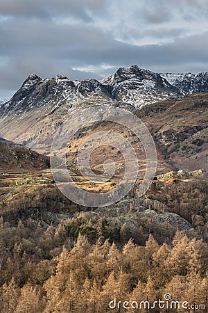 Majestic Winter landscape image view from Holme Fell in Lake District towards snow capped mountain ranges in distance in glorious Stock Photo