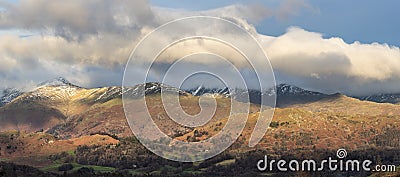 Majestic Winter landscape image view from Holme Fell in Lake District towards snow capped mountain ranges in distance in glorious Stock Photo