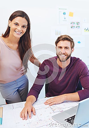 We make a great team. Cropped portrait of two young architects looking over some building plans. Editorial Stock Photo