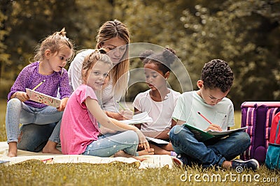 Make kids education fun. Teacher with children in nature. Stock Photo