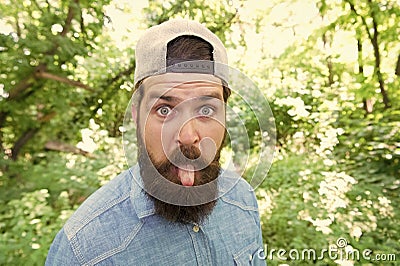 Make life worth living. summer day fun. bearded man looking funny. brunette bearded man wear cap in forest on background Stock Photo