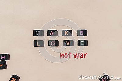 Make love not war. Black beads making phrase on beige background Stock Photo