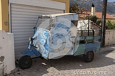 Beat-up old three-wheel truck in back lane in Greece Stock Photo