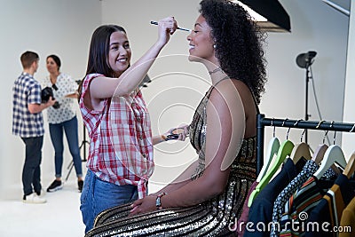 Make Up Artist Working On Fashion Shoot In Photographers Studio Stock Photo