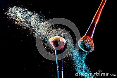 Make up cosmetic brushes with colorful shadows explosion on black background. Skin care or fashion concept Stock Photo