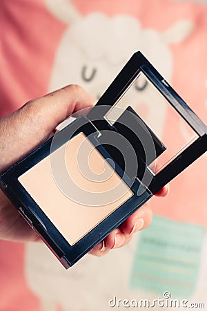 Fashion black powder palette in female hands on colorful background. Make up concept Stock Photo