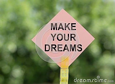 Make your dreams, text a piece of paper on notes on a green background. Concept desire to keep the selected goals and dreams Stock Photo