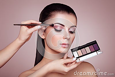 Makeup artist applies eye shadow Stock Photo