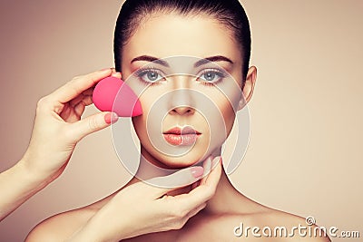 Makeup artist applies skintone Stock Photo