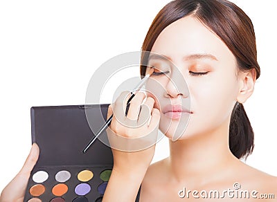 Makeup artist applying colorful eyeshadow on model's eye with a Stock Photo