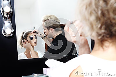 Makeup artist applying mascara on eye lashes of model Stock Photo