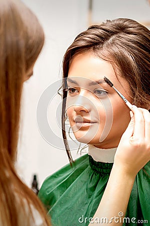 Makeup artist combing eyebrows for bride Stock Photo