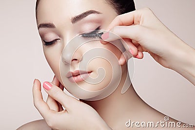 Makeup artist glues eyelashes Stock Photo