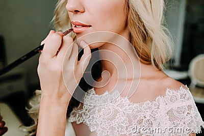 Makeup artist makes young beautiful bride bridal makeup. Morning preparation. Close-up hands near face Stock Photo