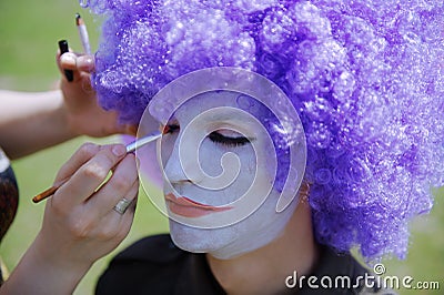 Makeup artist making clown face painting to the actor Stock Photo