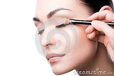 Makeup artist using brush to apply eye shadow on face of woman Stock Photo