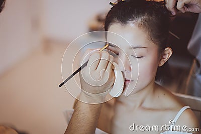 Makeup artist working on beautiful Asian model Stock Photo