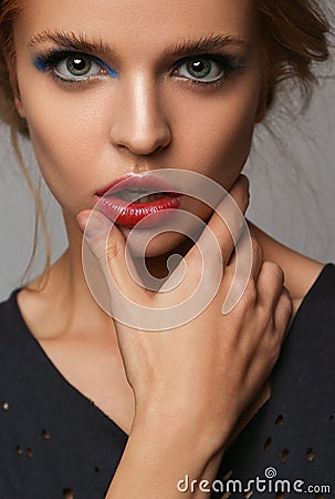 Makeup and beauty theme: beautiful girl with red lips and blue eyes in studio Stock Photo