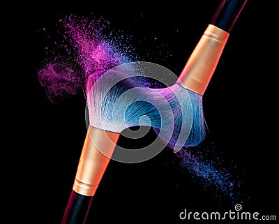 Makeup brush with blue powder explosion on black Stock Photo