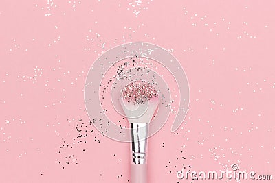 Makeup brush and shiny sparkles on pastel pink background. Festive magic makeup concept. Template for design, Top view Flat Lay Stock Photo