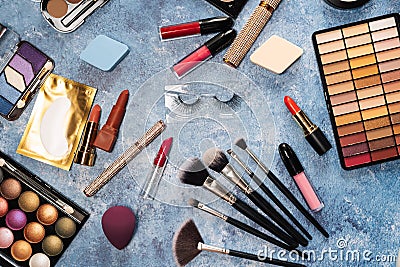 makeup brushes, decorative cosmetics, false eyelashes on a blue background. the view from the top Stock Photo