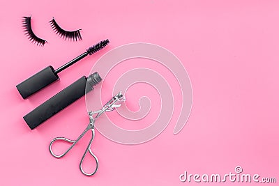 Makeup set for expressive eyelashes. Mascara, false eyelashes, eyelash curler on pink background top view space for text Stock Photo