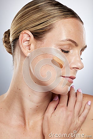 Makeup shade, cosmetics and face of a woman with foundation, facial cream and skincare on a grey studio background Stock Photo