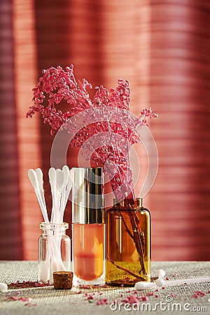 Makeup store desk with sunlit bottles, lipstick and cotton buds Stock Photo