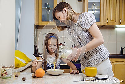 Making breakfest. Mom teach daughter to cook Stock Photo
