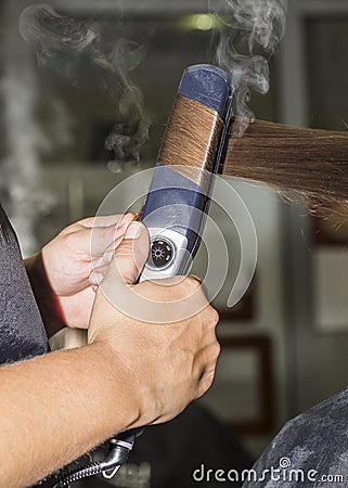 Making curles with hair iron at the hairdressers Stock Photo