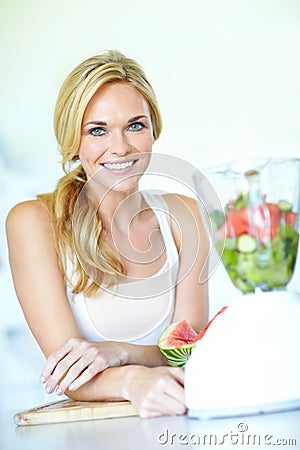 Making a delicious smoothie. Attractive young blonde woman making a watermelon smoothie. Stock Photo