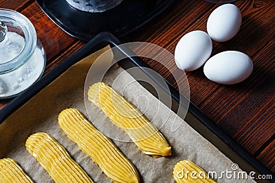 Making eclairs. Homemade Eclair. Series. Transferred on a baking sheet. Stock Photo