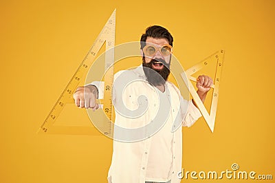 Making geometry fun. Funny hipster using geometrical tools at geometry. Geometry teacher holding triangles for school Stock Photo