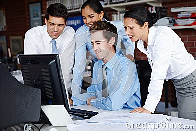 Making headway on an important project. An enterprising business team working on a project together on a computer. Stock Photo