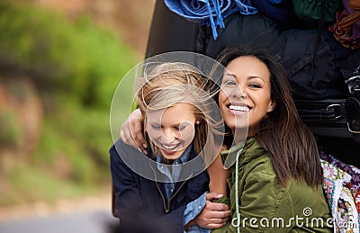 Making holiday memories with my best friend. two young women sitting in front of a car full of luggage. Stock Photo