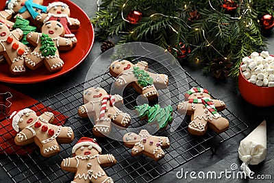 Making homemade Christmas cookies. Gingerbread people and festive decor on black table Stock Photo