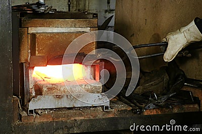 Making the knife out of metal at the forge. Heating of metal billets in the furnace. Stock Photo