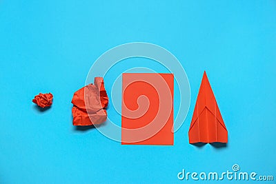 Making paper plane, trial and error. Flat lay composition with crumpled and folded sheets on light blue background Stock Photo